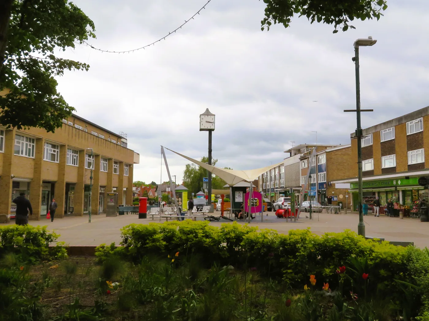 Woodley town centre and its clock, with festoon lighting strung across the precinct. The carol concert and switch-on is held here